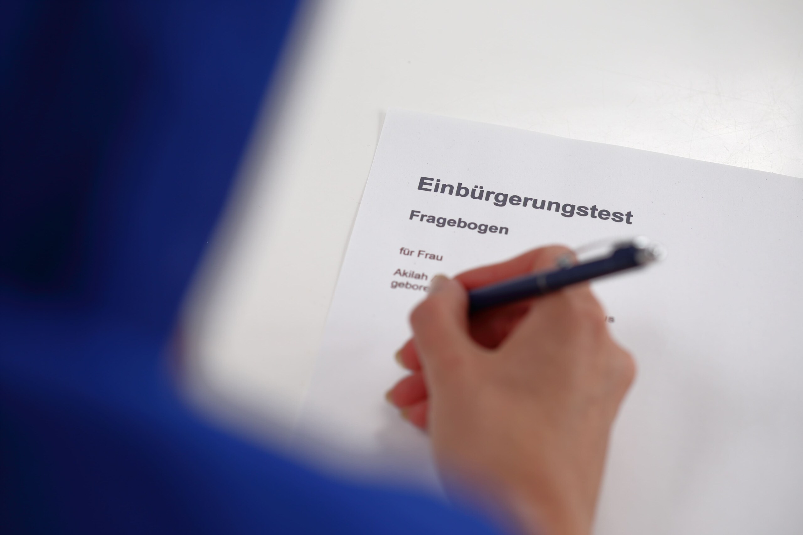 Eine Frau füllt den Fragenkatalog des Einbürgerungstest aus.